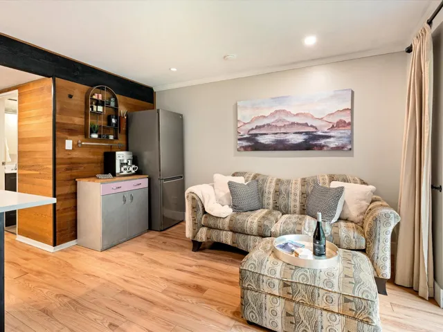 Living area with ornamental molding, light wood-style flooring, and recessed lighting