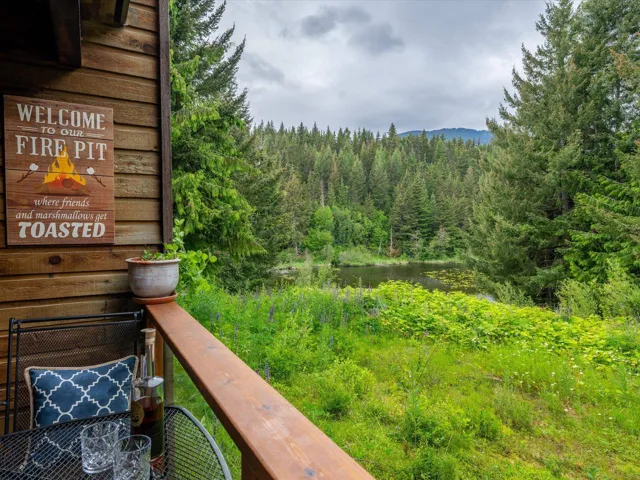 Balcony featuring a wooded view and a water view