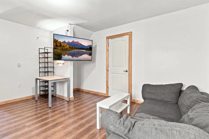 Interior space featuring wood-finish flooring, white walls, and wood trim