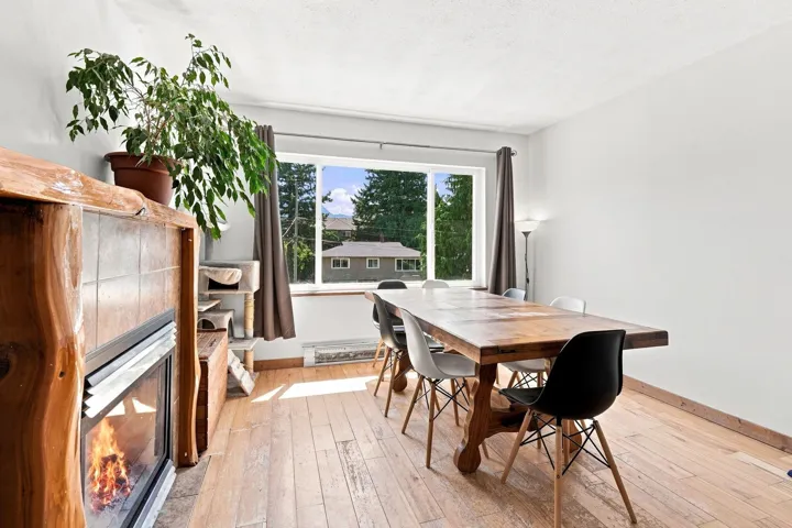 Wood-finish flooring throughout, featuring a natural wood mantel fireplace with tile surround, and a broad window
