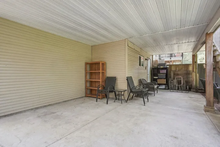 Expansive covered patio featuring a concrete slab floor, horizontal siding, and a white panel ceiling