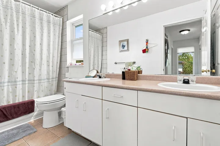 Bathroom featuring a double vanity with integrated sinks and white cabinetry