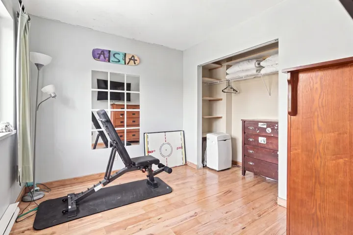 Room featuring wood-finish flooring, light grey wall paint, and a window with white trim