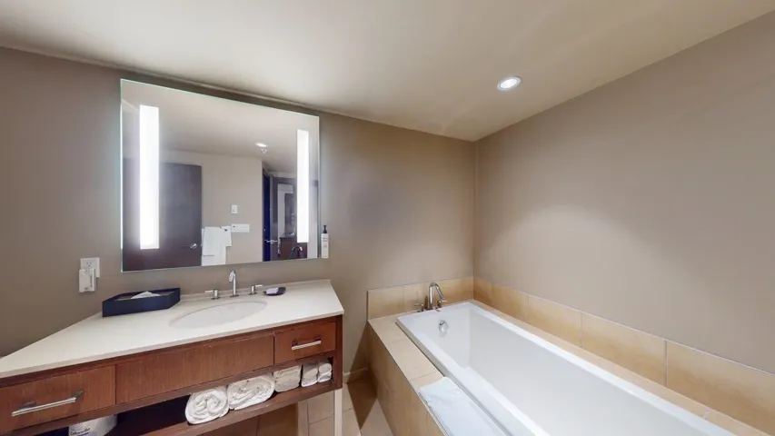 Bathroom featuring a garden tub, vanity, recessed lighting, and light tile patterned flooring
