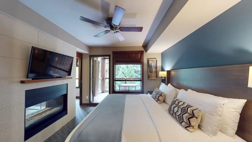 Bedroom featuring a tile fireplace and ceiling fan