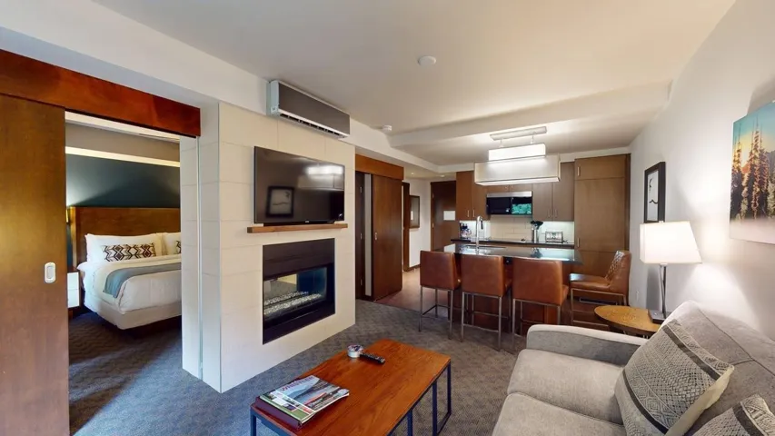 Living room with a tiled fireplace, a wall unit AC, and dark carpet