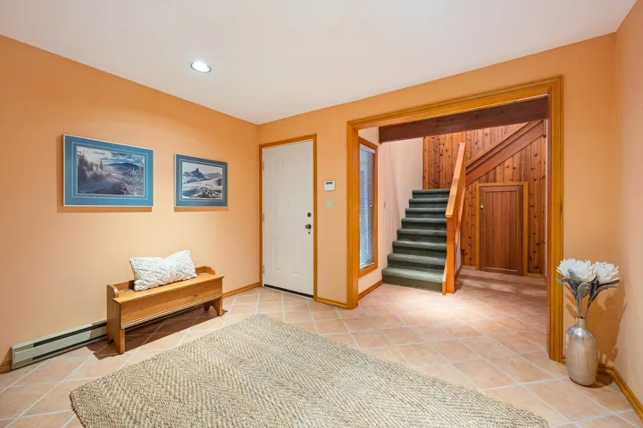 Entrance foyer with a baseboard radiator, light tile patterned floors, and recessed lighting