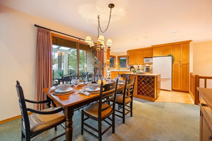 Dining room featuring hanging lights and light colored carpet