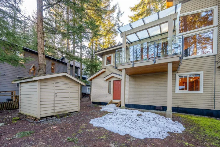 Rear view of house featuring a balcony and a storage shed
