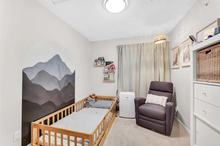 Bedroom featuring a crib and carpet