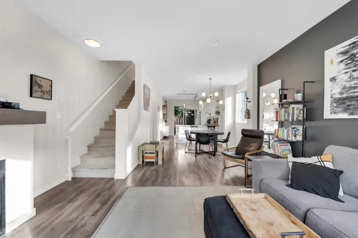 Living area with stairs, wood finished floors, and a chandelier