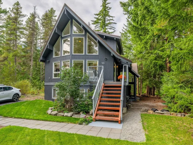 Rear view of house featuring a lawn and stairs