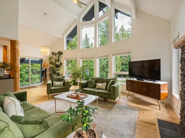 Living room featuring light wood-style floors, high vaulted ceiling, a chandelier, a wooden ceiling with exposed beams, and ceiling fan