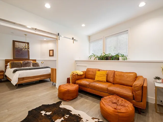 Bedroom with recessed lighting, a barn door, and wood finished floors