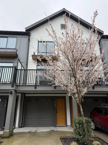 Back of house with concrete driveway, a balcony, and an attached garage