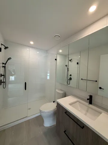 Full bath with a shower stall, vanity, recessed lighting, toilet, and marble finish floor