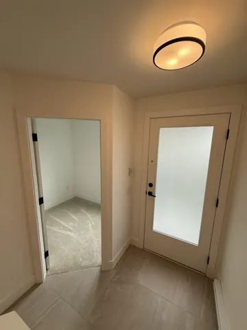 Doorway to outside featuring a baseboard heating unit and baseboards