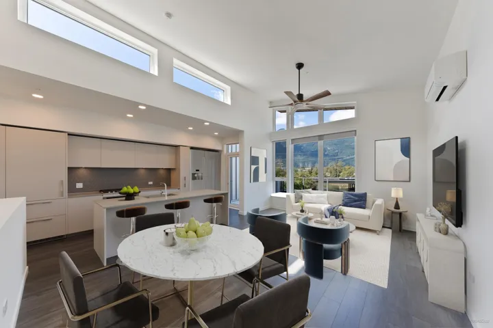 Modern kitchen featuring integrated appliances, flat-panel cabinetry, and a central island with bar seating