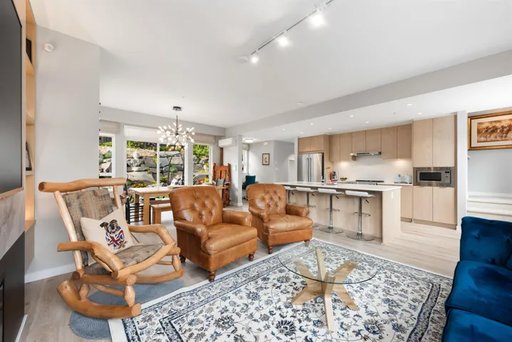 Living room featuring light wood-type flooring, a chandelier, track lighting, and recessed lighting