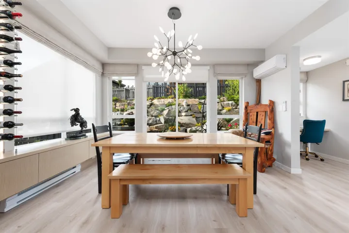Dining space featuring a wall mounted AC, light wood-style floors, and a chandelier
