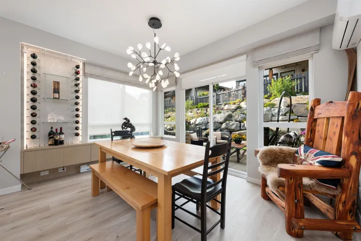 Dining room featuring an AC wall unit, light wood finished floors, and a chandelier