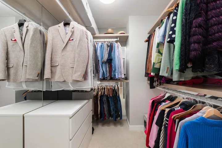 Walk in closet featuring light colored carpet