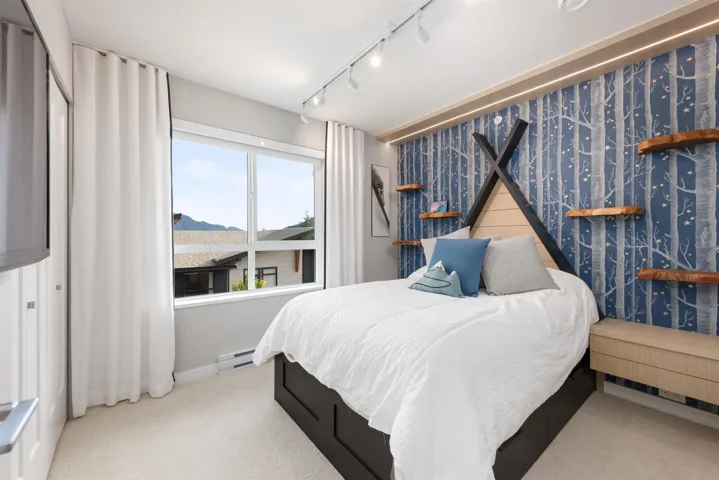 Carpeted bedroom with rail lighting and a baseboard radiator