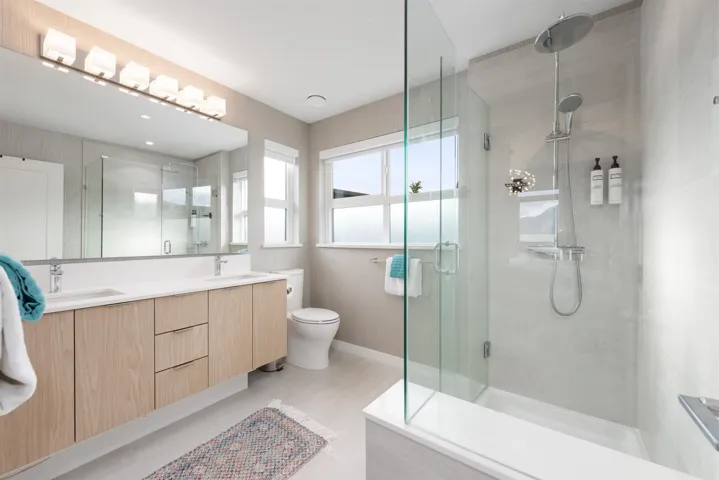 Bathroom featuring a shower stall and double vanity
