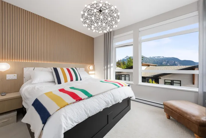 Carpeted bedroom featuring a baseboard heating unit, a chandelier, and a mountain view