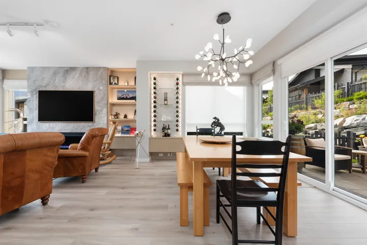 Dining area with healthy amount of natural light, light wood-style floors, a chandelier, and rail lighting
