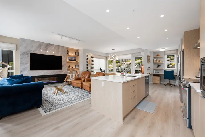 Kitchen with modern cabinets, light wood finished floors, an office area, light countertops, and dishwasher