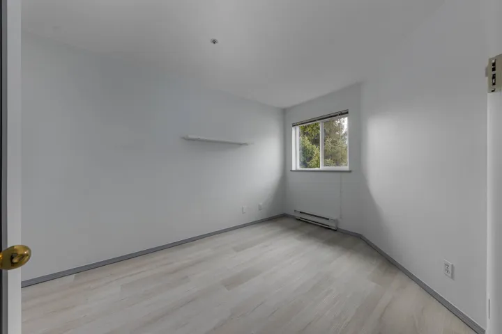 Unfurnished room with a baseboard heating unit and light wood-type flooring