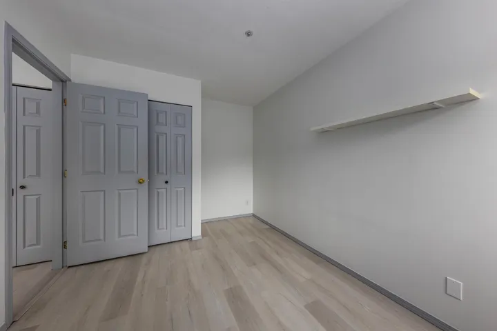 Unfurnished bedroom featuring light wood-type flooring, a closet, and lofted ceiling
