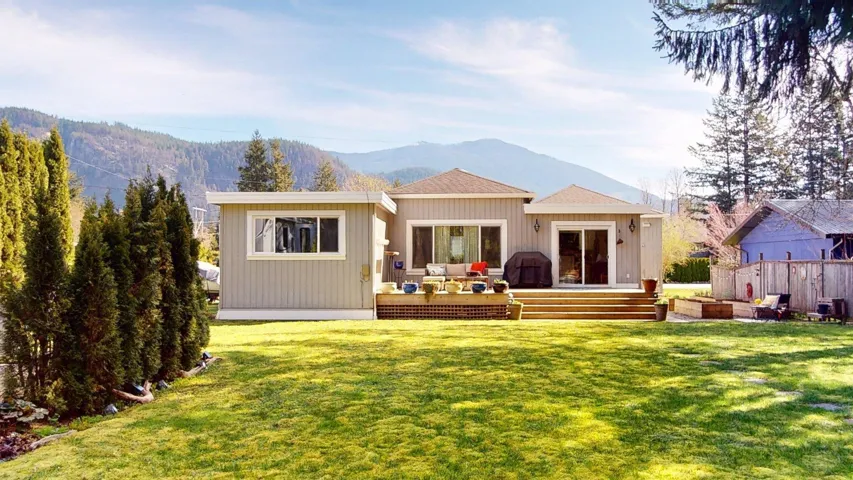 Back of property featuring a lawn, a mountain view, and an outdoor hangout area
