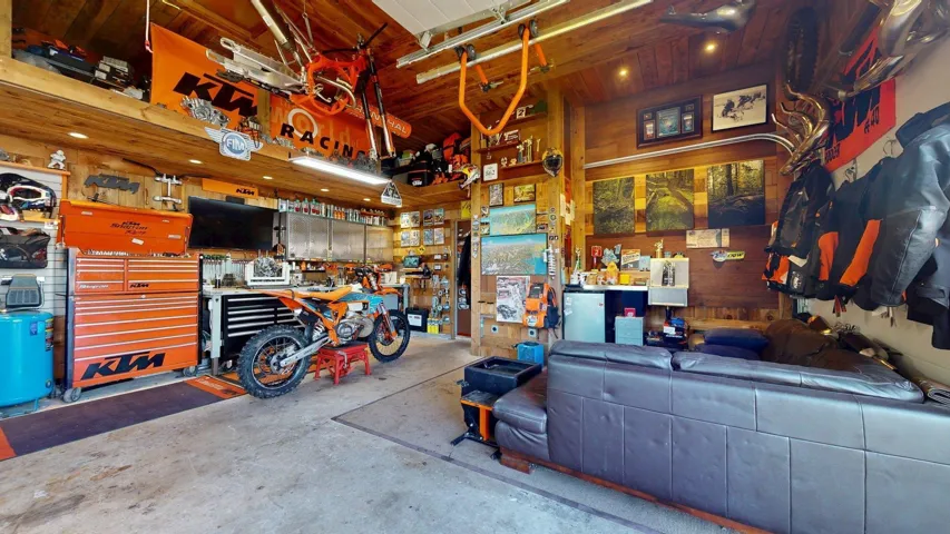 Garage featuring a workshop area, wood walls, and wooden ceiling