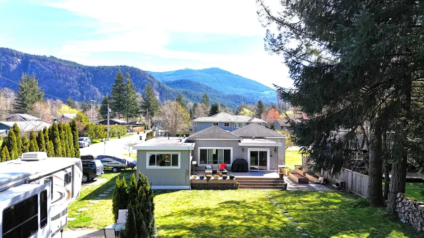Back of property with a deck with mountain view and an outdoor living space
