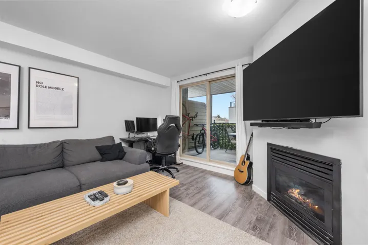Living area with a glass covered fireplace and wood finished floors