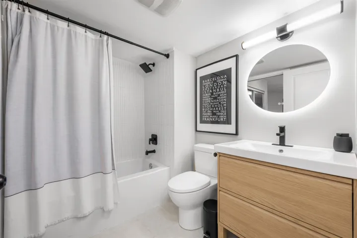 Full bath featuring shower / tub combo, vanity, toilet, and tile patterned floors