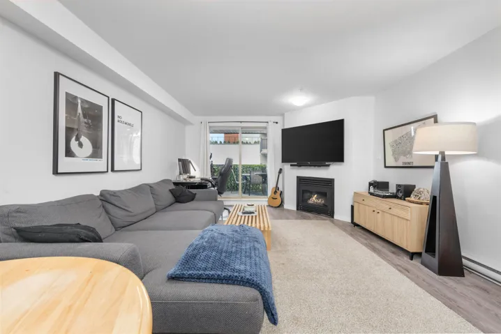 Living room featuring light wood-style floors and a glass covered fireplace
