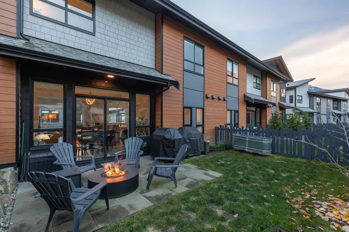 Rear view of house with a patio area, an outdoor fire pit, and roof with shingles