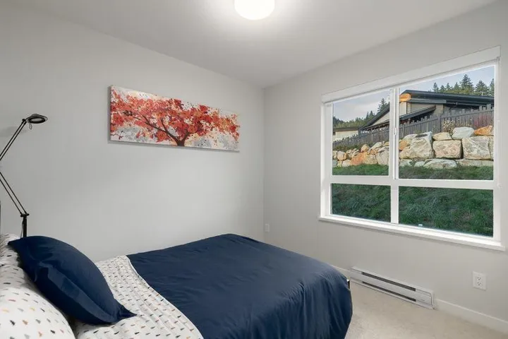 Carpeted bedroom with a baseboard radiator and baseboards