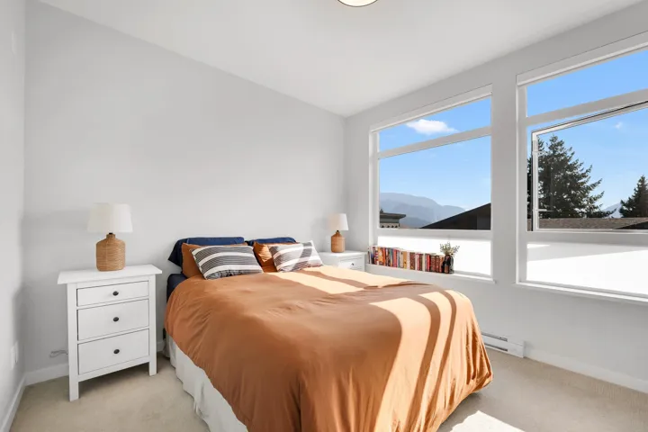 Bedroom featuring light colored carpet, baseboard heating, and a mountain view