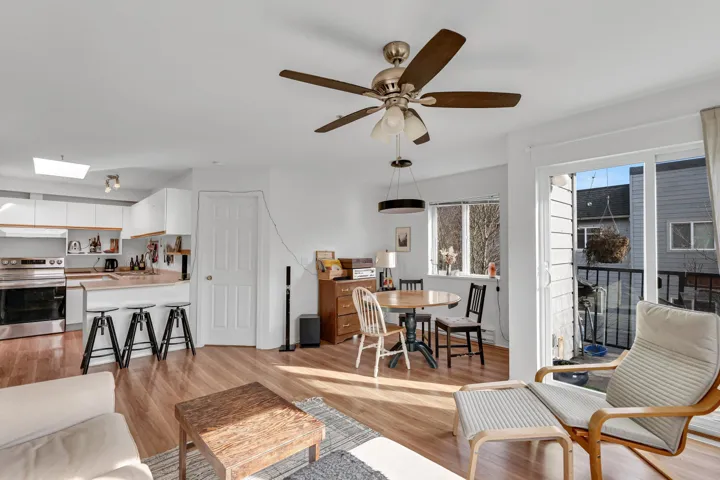 Living area featuring light wood finished floors, a skylight, and a ceiling fan