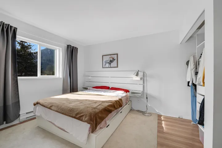 Bedroom featuring light wood-style flooring, a baseboard heating unit, and baseboards