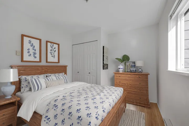 Bedroom featuring a closet, baseboard heating, and wood finished floors