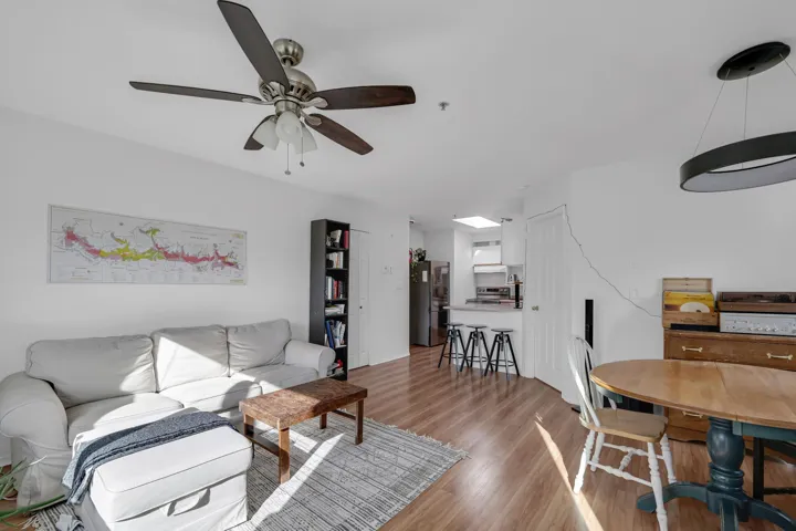 Living room with light wood finished floors and ceiling fan