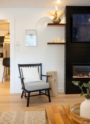 Sitting room featuring a large fireplace, baseboards, and wood finished floors