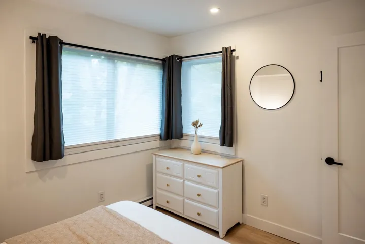 Unfurnished bedroom with recessed lighting, light wood-style flooring, a baseboard heating unit, and baseboards
