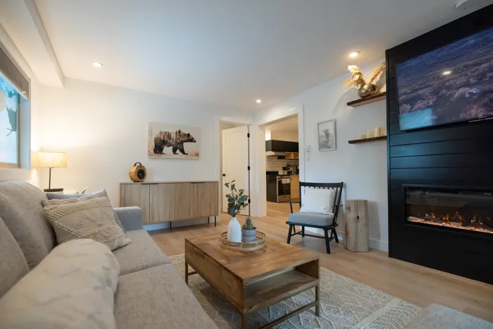 Living room with recessed lighting, light wood finished floors, and a large fireplace