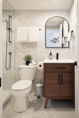 Full bath with marble finish floor, vanity, toilet, and a shower stall